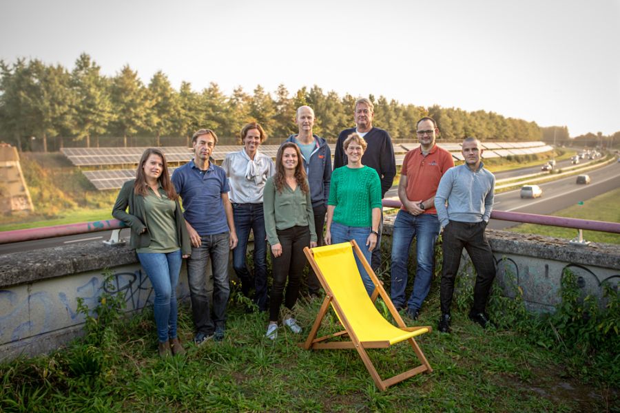 Het team van Vrijopnaam met het zonnepark aan de A58 in Etten-Leur op de achtergrond